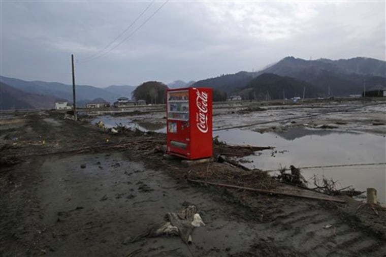 A vending machine stands intact in the area devastated by the  tsunami in Ishinomaki, Miyagi Prefecture, northern Japan, on Saturday.